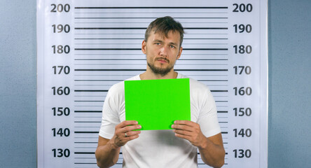 Closeup mugshot photo of man holding green screen blank sign in hands.