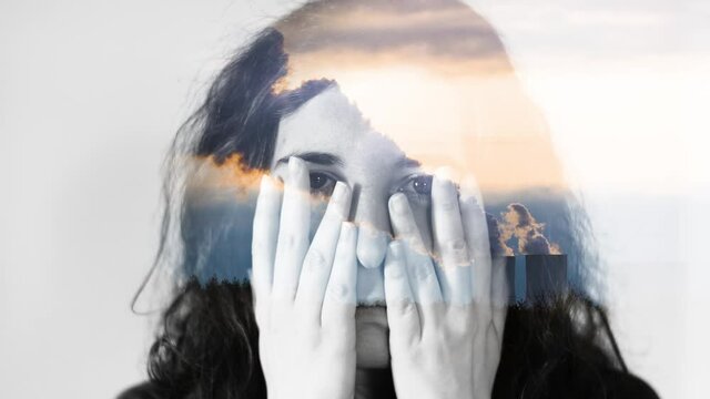 Cinematic double exposure portrait of female face and coal power plant. Concept of fear, climate change, air pollution, criticism, greenhouse gasses. Smoke overlay over covered eyes. 4K.