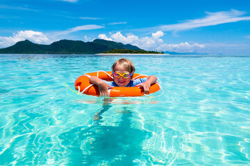 Child on tropical beach. Sea vacation with kids.