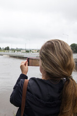 Fototapeta premium Woman from behind capturing flood