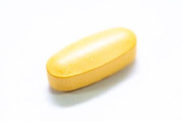 Orange medicinal pill close up macro shot isolated on white background.
