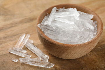Menthol crystals in bowl on wooden background