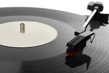 Closeup view of vinyl record on turntable against white background