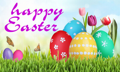 Happy Easter. Bright eggs and spring flowers on green grass outdoors
