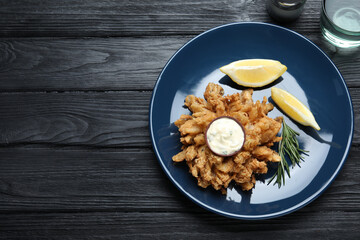 Fried blooming onion with dipping sauce served on dark wooden table, flat lay. Space for text