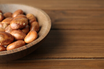 Plate of jackfruit seeds on wooden table, closeup. Space for text