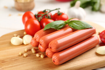 Fresh raw vegetarian sausages and vegetables on wooden board, closeup