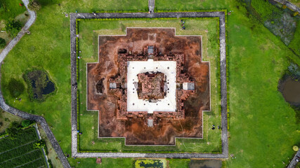 Aerial drone view of Blandongan temple at Karawang and surrounded by green grass with noise cloud....