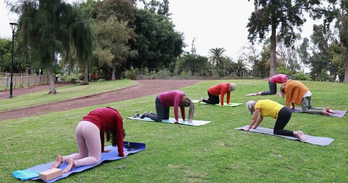 People doing yoga class keeping social distance at city park - Healthy lifestyle and sport during coronavirus outbreak - Healthy lifestyle concept