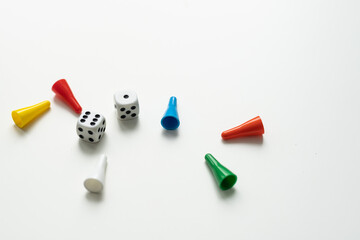 Multi-colored playing chips and dice cubes are grouped together on a white background: the concept of Board games, entertainment, background, games at home for the whole family