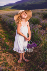 The little girl collects flowers on a lavender field