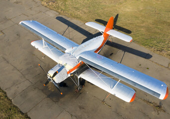 A small plane stands in the parking lot of an old airfield. Wings. Airport. Airfield. Flights by...