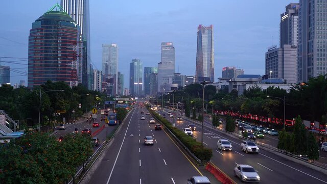 Traffic rushing an highway in Jakarta modern downtown district in Indonesia capital city at nightfall with modern skyline in the background