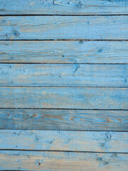 Old wooden planks painted with peeling blue paint.