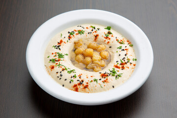 Chickpea cream hummus, typical arabic food on wooden background.