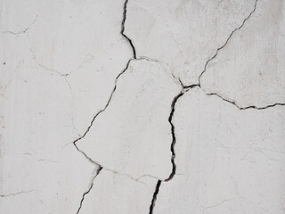 Cracks on the white wall.