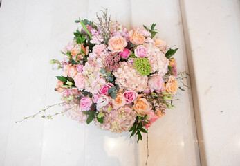 Fototapeta na wymiar a large bouquet of pink, white flowers, on a light staircase. Bouquet, composition for a holiday, celebration. Flower trade, private business, floristic decoration