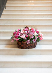 Fototapeta na wymiar a large basket of flowers, a bouquet of pink, white flowers, on a light background. Bouquet, flower arrangement for a holiday, celebration. Flower trade, private business, floristic decoration