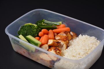 Healthy balanced lunch boxes. Grilled chicken, carrots, cucumbers, broccoli, and white rice. Lunch...