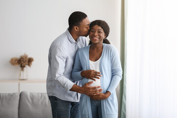 Loving black man kissing his pregnant wife
