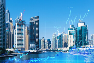 Fototapeta premium Skyscrapers of Dubai business downtown. International hub of trading and financial services of Western Asia. FOREX graph and chart concept. Double exposure. Dubai Canal waterfront.