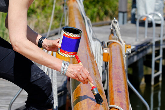 Varnishing the wooden mast of a classic sailing yacht