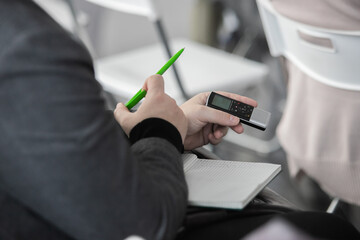 Journalists making news, struggling to get answers. Focus on voice recorder, blurred crowd