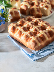 Homemade Hot Cross Buns on a light concrete background. Traditional Easter food. Easter holiday concept.