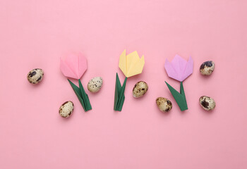 Quail eggs and origami tulips on pink pastel background. Easter composition. Top view
