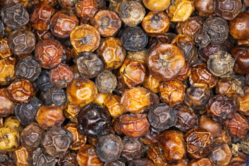 Full frame wallpaper macro closeup of whole grain  peppercorns - cambodian black kampot pepper