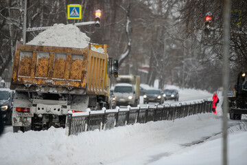 Naklejka premium Communal services worker sweeps snow from road in winter, Cleaning city streets and roads during snowstorm. Moscow, Russia