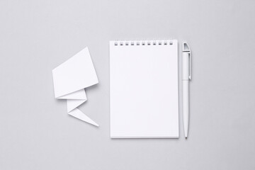 Notebook and Paper cut comic dialog cloud on gray background. Copy space