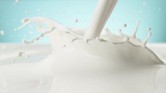 Super slow motion of pouring milk on soft blue background. Filmed on high speed cinema camera, 1000 fps.