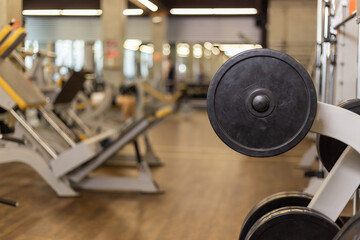 Barbell disc on blurred gym interior background