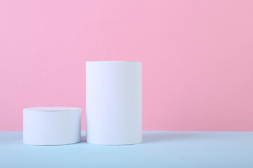 Minimalistic background of geometric shapes. Two cylinders on a blue pink pastel background