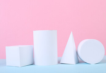 White geometric figures on a blue-pink pastel background. Composition of different geometric objects. Concept art. Abstract background, minimalism