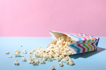 Bucket of sprinkled popcorn on blue pink pastel background