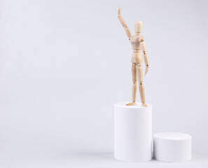 Wooden puppet on a pedestal. White background. Level up. Career growth