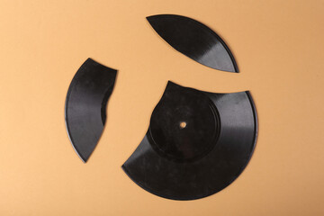 Broken vinyl record on beige background