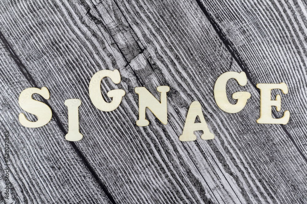 Fototapete Signage concept with design template on old diagonal wooden boards and alphabet letters in a wavy line with copyspace above and below