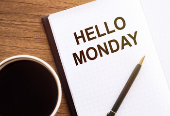 HELLO MONDAY - text on notepad on wooden desk.