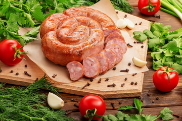 Juicy, appetizing tasty, natural, homemade smoked sausage is spiral cut on a wooden board with...