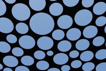 Circular punched steel plate against blue sky background