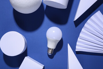 Minimalism blue background with  geometric shapes and light bulb. Trendy shadows