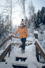 Femme jeune et belle en hiver dans la forêt froide et enneigée