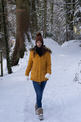 Femme jeune et belle en hiver dans la forêt froide et enneigée