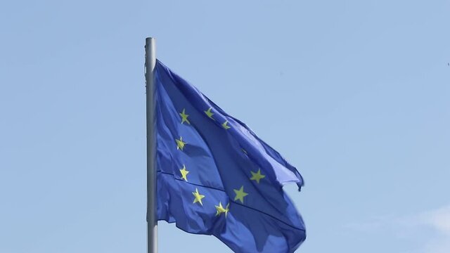 Video of European union flag, stars and blue color on the blue sky. Close-up of flag moving during the wind, windy weather in Tbilisi, Georgia.