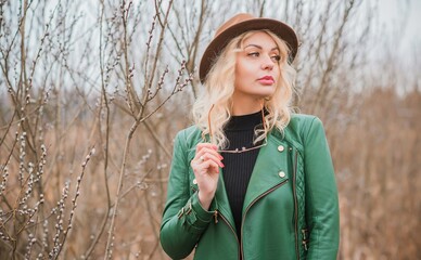 Woman wear eco leather green jacket, Fedora brown hat and vintage aviator glasses , belt with a...
