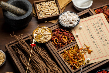 Ancient Chinese medicine books and herbs on the table