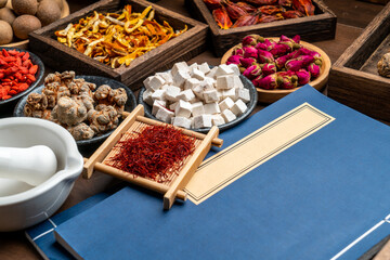 Ancient Chinese medicine books and herbs on the table